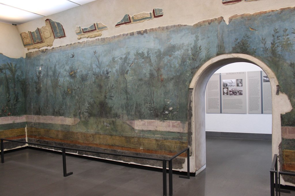 IMG_6768.JPG -  Triclinium of Livia .  In the triclinium of Livia, decorated with plants and birds like a flourishing garden, everything changed tonalities in relation to the change of natural light. In order to see the frescoes in the conditions of the original setting, a sophisticated system of biodynamic light has been installed, reproducing the change of the sunlight 'colour' during the day (after the sunset the light is kept on a mean value). The entire day cycle is reproduced in the space of few seconds at the beginning of each hour in order to emphasize the variations of the diurnal light.  National Museum of Rome - Palazzo Massimo alle Terme 