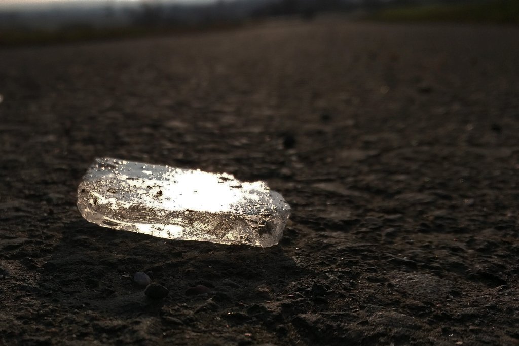 IMG_20160217_093218_c.jpg - Ice fragment. Unfortunatly this is not on a Islandic beach, but instead only a paved road with some ice fragment from a nearby frozen puddle. Maybe some car has broken this one out. Picture was take by a mobile phone during a morning run.